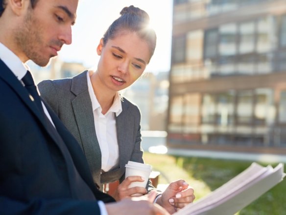 Property managers reviewing documents outdoors in Vancouver while discussing rental property management services and strategies.